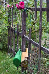 Gießkannen an einem Zaun in einem Kleingarten