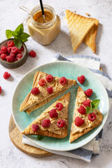 Sweet dessert sandwich breakfast. Tasty bread toasted with peanut butter and raspberry on a stone tabletop.