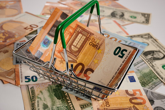 Euro banknotes in a metal basket - photo on money banknotes. Euro paper banknotes in toy metallic shopping cart. USD and EUR currency banknotes. Commercial result of shopping for sellers. Real money.