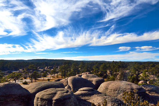 Jardin de piedras volcanicas gigantes con un cielo azul con nubes y un bosque de coniferas en el fondo en la sierra madre occidental en mexiquillo durango mexico 