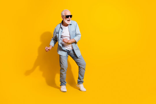 Full length body size view of attractive cheerful funky grey-haired man dancing isolated over vivid yellow color background