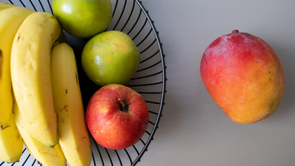 healthy fruits in a basket. Banana, orange, apple, mango, limon.