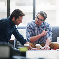 Partnering up on the project. Shot of two coworkers in a meeting in an office.