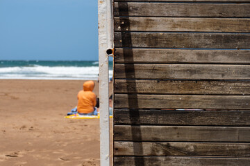 Copy space for text on a wooden background and a warm person on the beach.