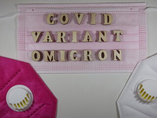 The word covid variant omicron in wooden letters on the face mask. High quality photo