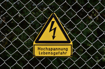 Deutsches Hochspannungs-Schild am Zaun