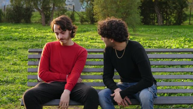 A boy is comforted by his friend in the park