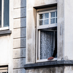 Arm und Hand mit Zigarette aus einem Fenster