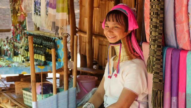 Karen Long Neck woman (Padaung) weaving and smiling at hill tribe village near Chiang Rai, northern Thailand. 