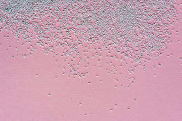 Papel rosado de cartulina  de fondo con piedritas de color turquesa a modo de textura puntillista...