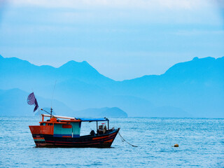 Sunset on the coast of Itagua beach, Ubatuba (Sao Paulo - Brazil). Old traditional fishing boat...