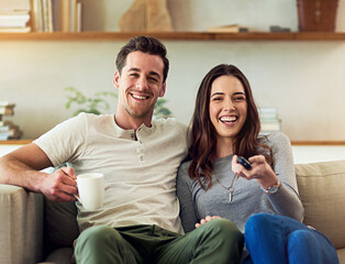 We never miss an episode. Portrait of a happy young couple relaxing on the sofa and watching tv together.