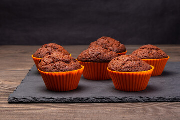 chocolate cupcakes in silicone molds on a dark background