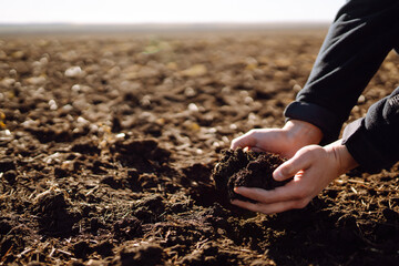 Hand of expert farmer collect soil and pouring to another hand to check quality and prepare  soil...