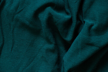 dark green crumpled knitted fabric as background close-up