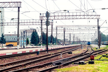 Railway station with rails, buildings and trains in the distance