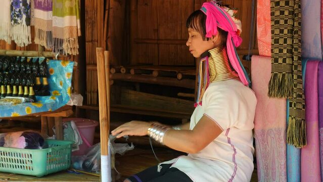 Karen Long Neck woman (Padaung) weaving and smiling at hill tribe village near Chiang Rai, northern Thailand.