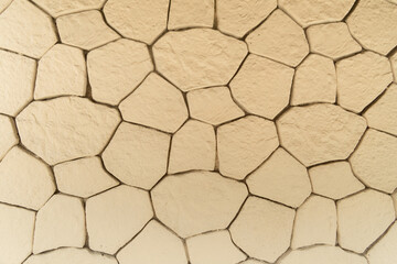Abstract beige background. Cracks in the form of a grid on a stone wall. Cracked background.