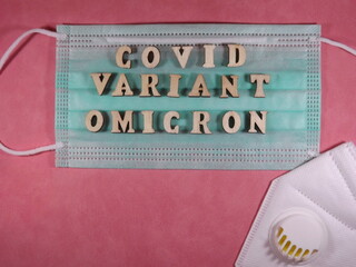 The word covid variant omicron in wooden letters on the face mask. High quality photo