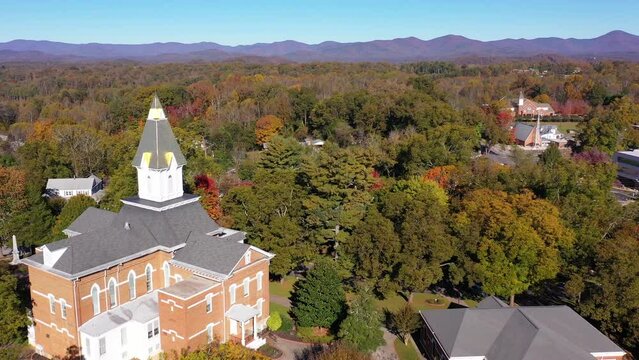 Nice aerial establishing shot of Blue Ridge Mountain Appalachian town of Dahlonega, Georgia with church steeple foreground.