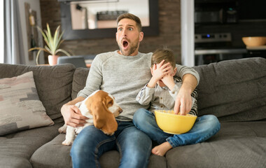 Father or Godfather with Basset dog having fun on the living room At Home watching movie with...