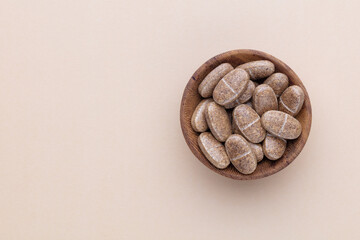 Alternative medicine tablets on a wooden spoon.