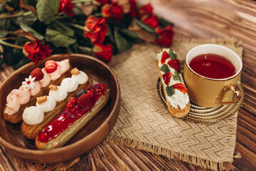 plate with cakes and a cup of tea on a wooden table