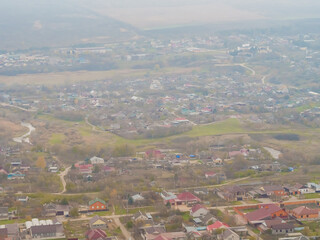 View of the village with small houses from the window of the plane. Soft focus