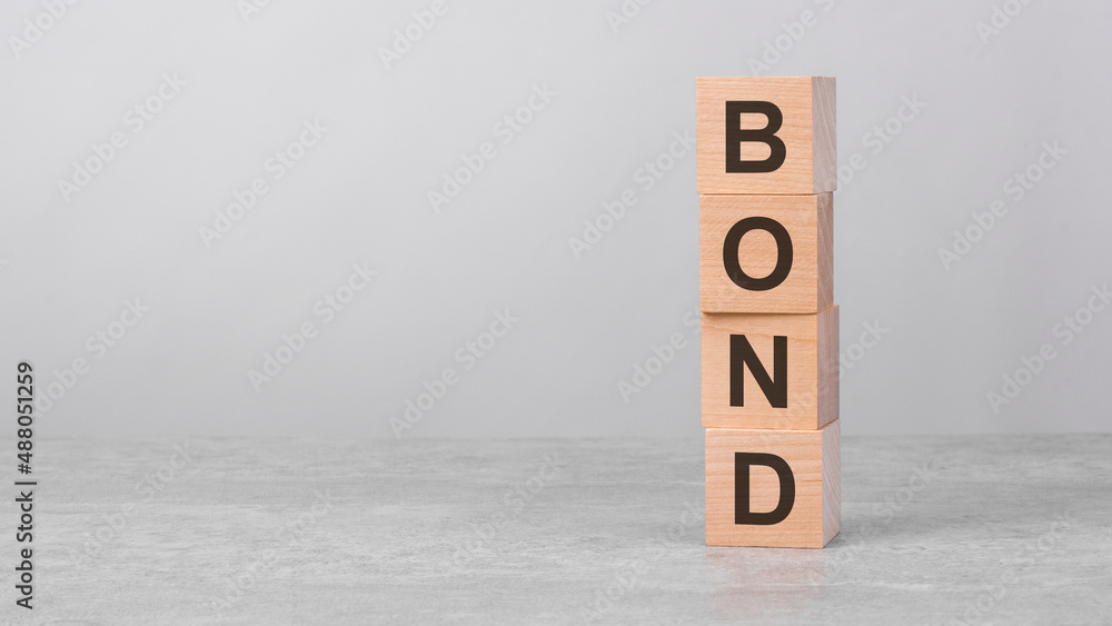 Poster wooden cube on a table with text bond. copy space on left for design, gray background