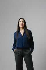 Middle-aged woman smiling friendly and looking in camera. Studio portrait.