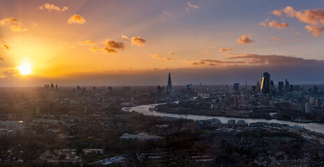 Wide panoramic view of the urban skyline of London, England, during a colorful sunset