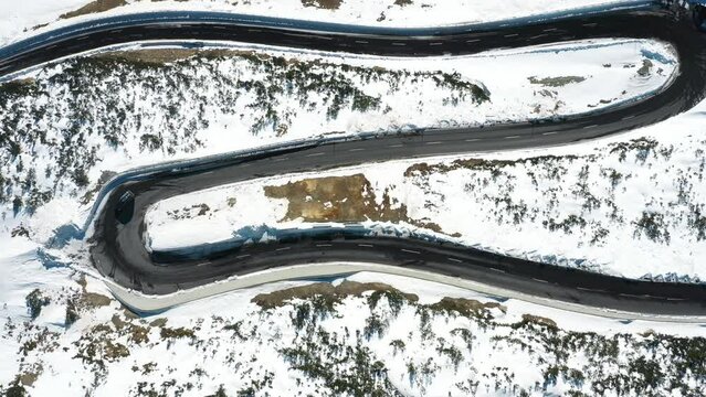 2022 - Excellent bird's eye view of a car driving along the S curve from wintry Davos to St. Moritz, Switzerland.