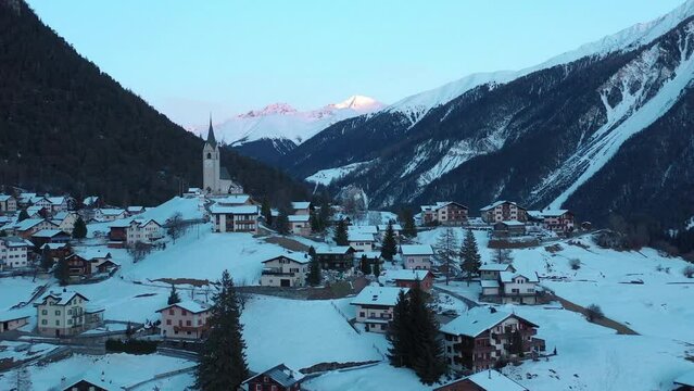 2022 - Excellent aerial view of the wintry mountain town of Schmitten, Switzerland at sunset.