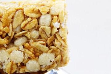 tasty granola oats bar closeup on white background with copy space