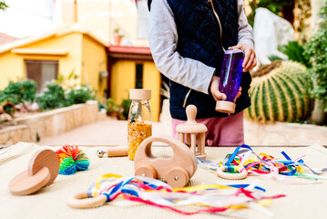 3 year old girl play with colorful educational alternative wooden toys.