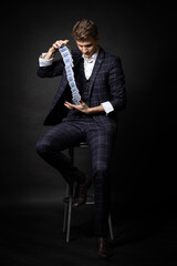 Fototapeta premium Man shows anaconda trick with deck of playing cards. Magician's Performance. Isolated on black background.