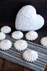 White delicious meringue on a dark background with a decorative heart