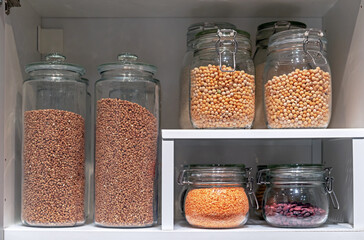 Glass jars with various cereals and grains. Foods storage concept .