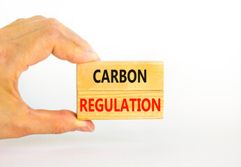 Carbon regulation symbol. Concept words Carbon regulation on wooden blocks on a beautiful white table white background. Businessman hand. Business and carbon regulation concept, copy space.