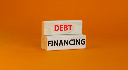 Debt financing symbol. Concept words Debt financing on wooden blocks on a beautiful orange table orange background. Business finance and debt financing concept, copy space.