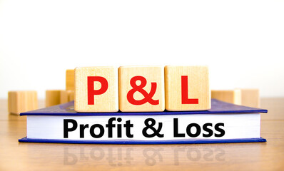 P and L profit and loss symbol. Concept words P and L profit and loss on wooden cubes on book on a beautiful wooden table, white background. Business and P and L profit and loss concept. Copy space.