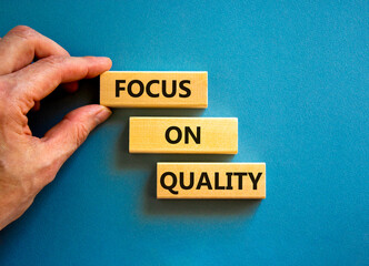 Focus on quality symbol. Concept words Focus on quality on blocks on beautiful blue table blue...
