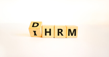 DHRM, domestic or international human resource management IHRM symbol. Words DHRM, IHRM on cubes on a beautiful white background. Businessman hand. Business, DHRM IHRM concept. Copy space.