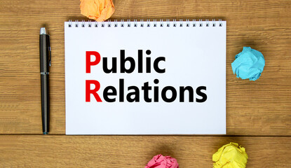 Fototapeta premium PR public relations symbol. Concept words PR public relations on white note. Metallic pen. Beautiful wooden background. Copy space. Business and PR public relations concept.