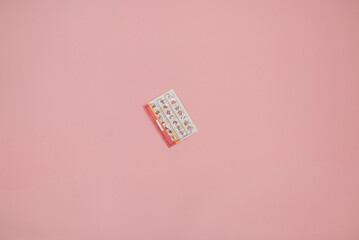 Female oral contraceptive pills blister on pink background. Women contraceptive hormonal birth...