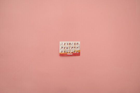 Female oral contraceptive pills blister on pink background. Women contraceptive hormonal birth control pills. Planning pregnancy concept. Copy space, flat lay.