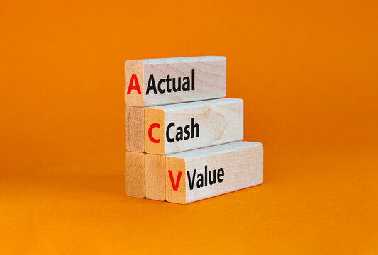 ACV actual cash value symbol. Concept words ACV actual cash value on blocks on a beautiful orange table, orange background. Business and ACV actual cash value concept. Copy space.