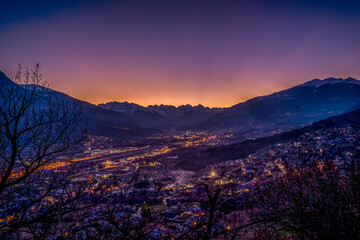 sunset over Aosta city with snow-capped mountains in the background and colorful sky