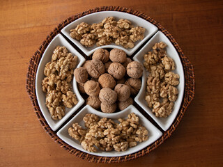 Tray of walnuts in shell and butterflied walnuts taken from above on wooden table