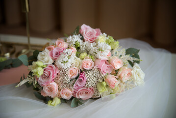 Bouquet of white and pink roses on the table in the composition. On a white canvas. Bridal bouquet.